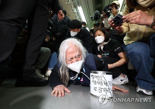 전국장애인철폐연대(전장연) 소속 장애인들이 지난 3일 오전 서울 지하철 3호선 경복궁역에서 출근길 지하철 탑승 시위를 하고 있다. <연합뉴스>